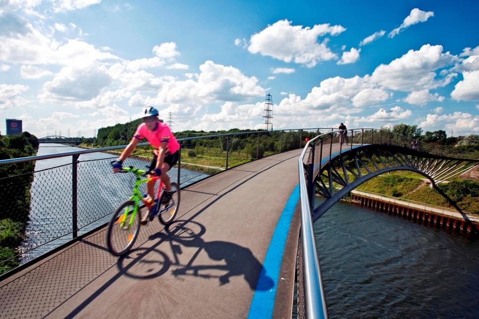 Cyclist on narrow modern bridge
