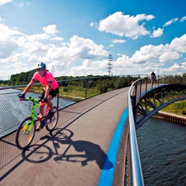 Cyclist on narrow modern bridge